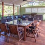 Warner deck extension build view of table with chairs with bbq and sofa in the background
