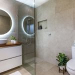 Batroom renovations Brisbane wide with Turul: bathroom renovated in a modern stile with dark tiles, glass shower cabin and round mirror